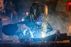 Close-up of welder working in workshop. Low depth of focus